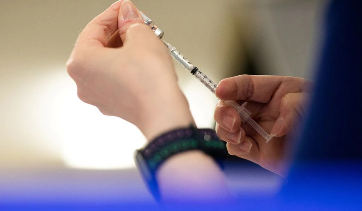 A nurse fills up syringes